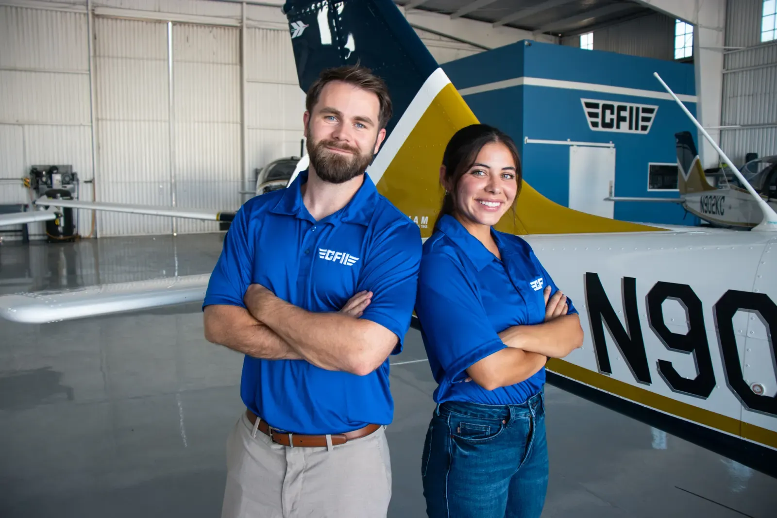 A CFII instructor and a student standing in the hangar in front of a P-Mentor